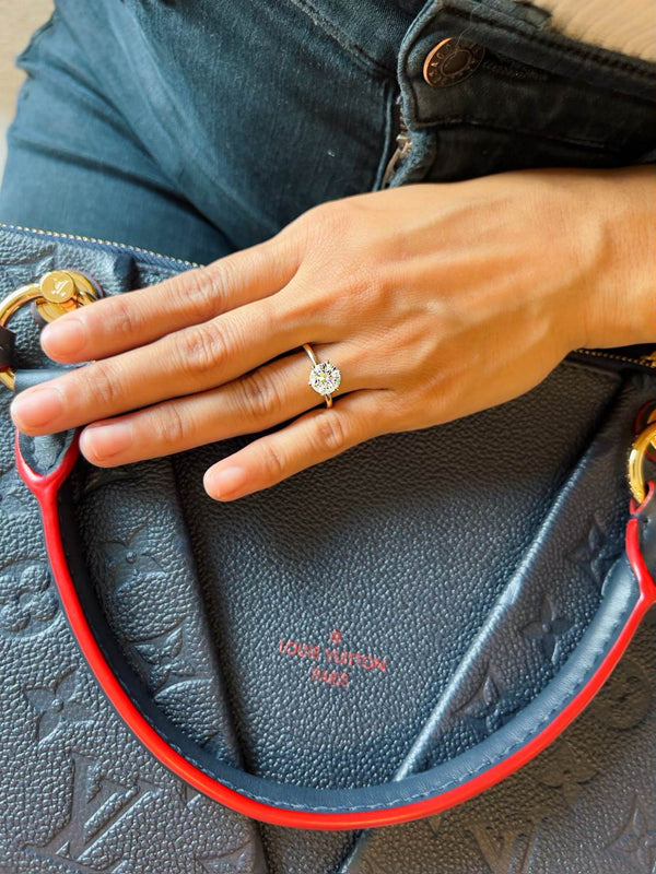 Hand with a Moissanites ring holding a Louis Vuitton 