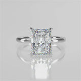 Elongated radiant cut centre stone with rounded plain band. Accent diamond gallery and non-cathedral setting. 