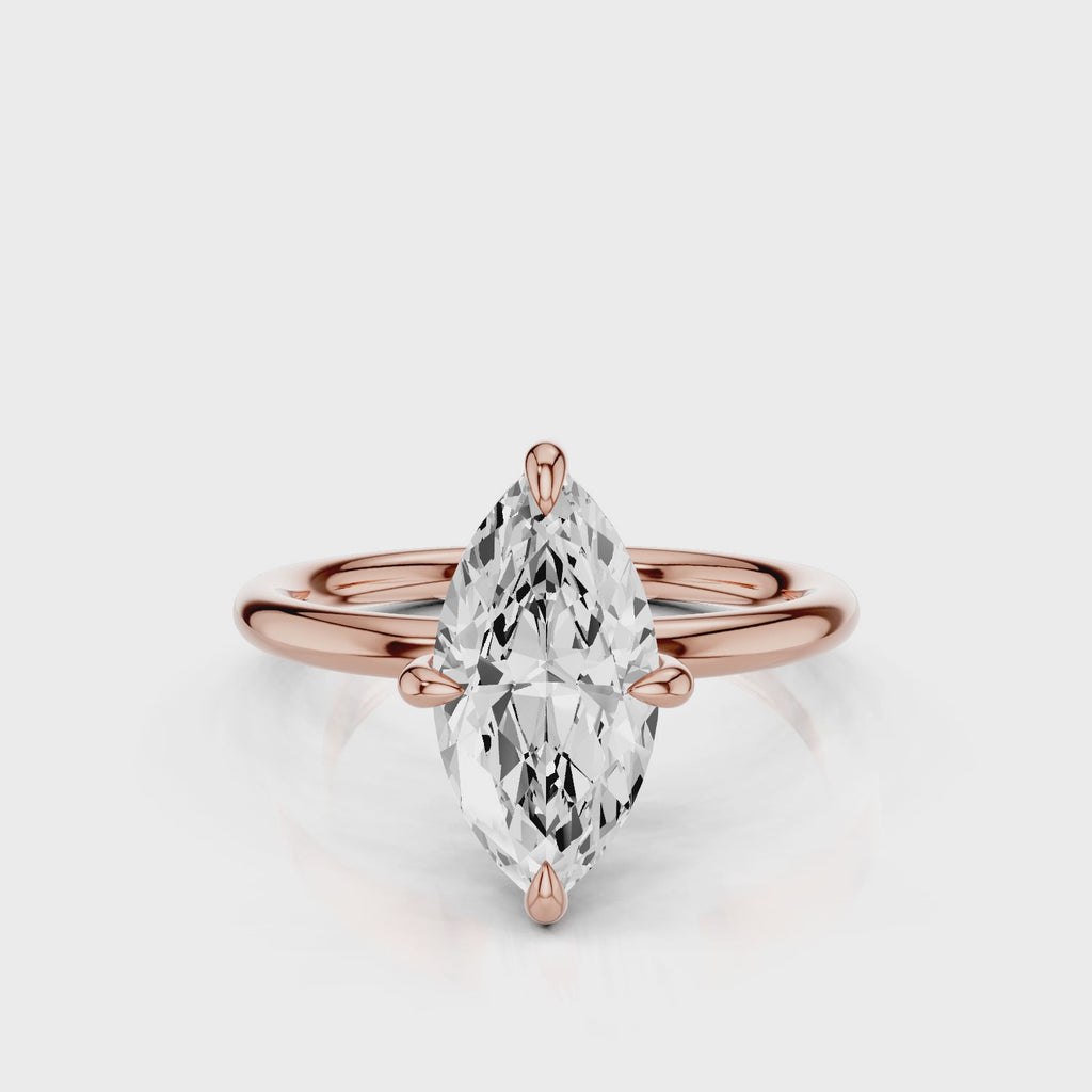 A silver engagement ring with a marquise-shaped lab created colorless centre stone, set in a full cut round brilliant lab grown diamond setting with a reverse halo video  Rose Gold