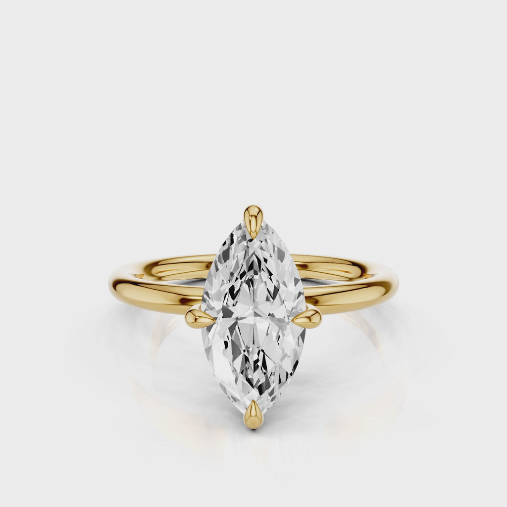A silver engagement ring with a marquise-shaped lab created colorless centre stone, set in a full cut round brilliant lab grown diamond setting with a reverse halo video Yellow Gold