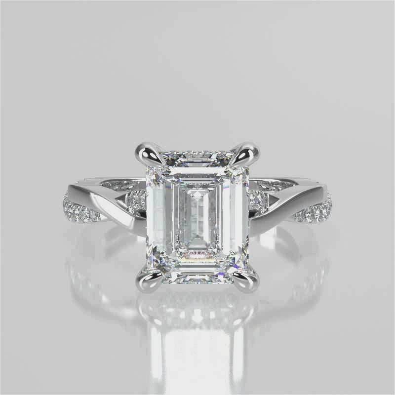 Elaine Emerald lab diamond engagement ring. Four prongs, tiger claws with a twisted band and cathedral setting. French pave set diamond gallery and french pave set diamond brigde.