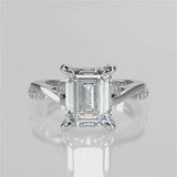 Elaine Emerald lab diamond engagement ring. Four prongs, tiger claws with a twisted band and cathedral setting. French pave set diamond gallery and french pave set diamond brigde.