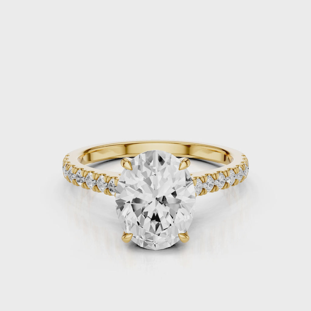 Dantella Oval lab diamond engagement ring with four prongs. Reverse seamless halo, cathedral, single row diamond band with floral basket design. Yellow Gold