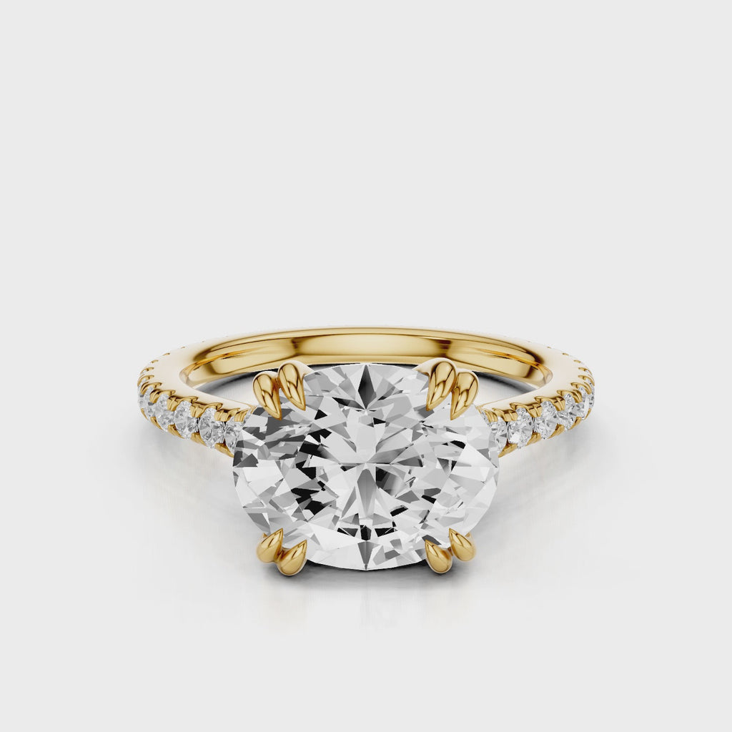Nailah Oval lab diamond engagement ring in east west setting and tiger claw prongs and a french pave band video Yellow Gold